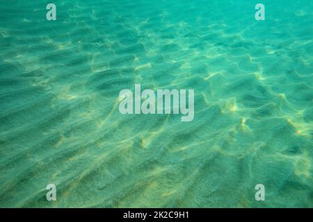 Oceano pavimento foto subacquee, sabbia 'dunes' illuminata dalla luce del sole. Abstract sfondo marino. Foto Stock