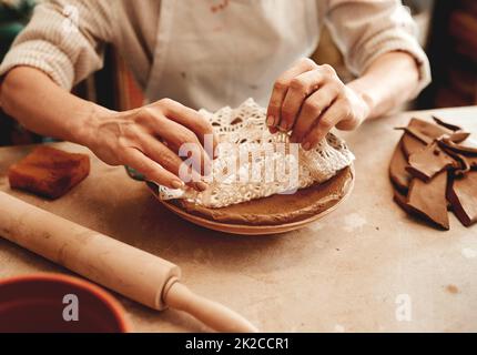 Questo disegno venderà come hotcakes. Scatto ritagliato di un artigiano irriconoscibile che lavora in un laboratorio di ceramica. Foto Stock