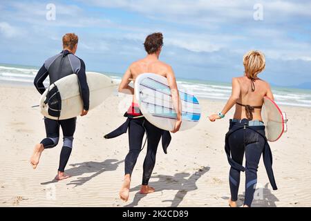 Il surf non è più rinvigorente. I giovani surfisti sono entusiasti di colpire le onde impressionanti. Foto Stock