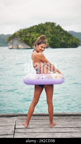 Tempo di nuoto. Ritratto a tutta lunghezza di una giovane donna attraente che si sente giocosa e in piedi in un tubo da bagno prima di andare a nuotare. Foto Stock