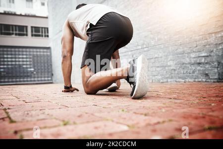 Preparati a sconfiggere i tuoi obiettivi. Scatto retrospettivo di un giovane sportivo che si esercita all'aperto. Foto Stock