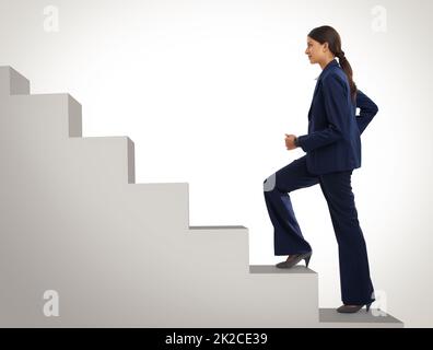 Lei non si fermerà ancora lei arriva in cima. Studio girato di una donna d'affari motivata che sale una rampa di scale. Foto Stock