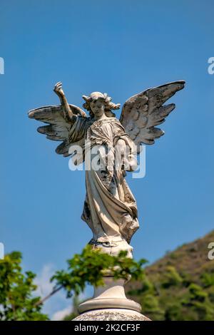 Un angelo con una tromba in mano in piedi su un piedistallo Foto Stock