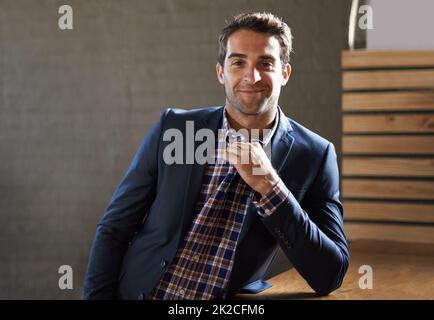 Posso comprarti un drink. Ritratto di un bel giovane uomo in piedi felicemente accanto ad un bancone bar. Foto Stock