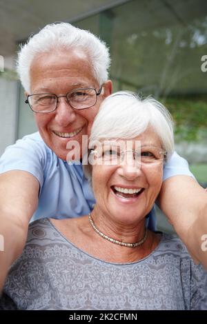 Lascia prendere uno per i bambini. Scatto di una coppia anziana che si posa per un selfie. Foto Stock