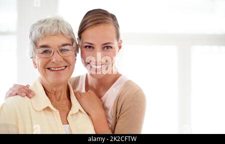 Lei significa il mondo per me. Ritratto di una giovane donna sorridente e la sua madre anziana legame. Foto Stock