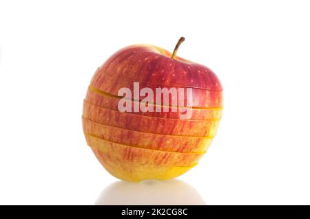 Primo piano su uno sfondo bianco isolato rosso luminoso, succosa mela fresca tagliata a fette. Foto Stock