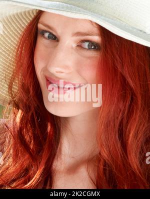 Fiery estate. Una giovane donna rossa che indossa un cappello da sole. Foto Stock