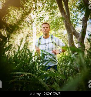 Trail running - tutto sulle esperienze lungo il percorso. Scatto di un giovane che corre lungo un sentiero natura. Foto Stock