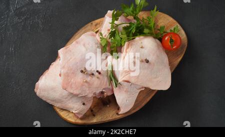 Coscia di pollo cruda sul tagliere con spezie. Foto Stock