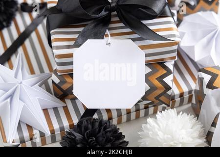 Confezione regalo con etichetta regalo vuota e primo piano arco nero, etichetta Mockup Foto Stock
