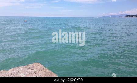 vista dal molo del mare alla zona d'acqua della spiaggia con boe di sicurezza restrittive e barche sullo sfondo, il concetto di una vacanza al mare Foto Stock