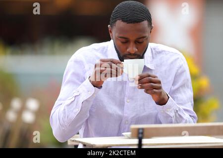 Uomo con pelle nera bere caffè in un bar Foto Stock