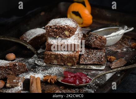 pezzi quadrati di brownie al cioccolato al forno cosparsi di zucchero a velo sul tavolo Foto Stock