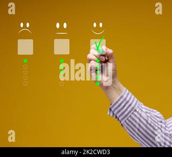 Concetto di servizio clienti e soddisfazione. La mano di una donna tocca lo schermo virtuale sull'icona di un'emoticon felice per ottenere la soddisfazione del servizio. Valutazione elevata Foto Stock