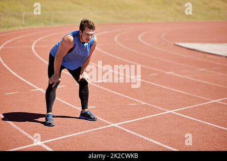 HES pronto a correre. Scatto di un bel giovane corridore in pista. Foto Stock