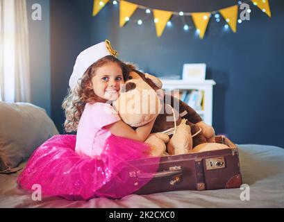 Sulla strada per la terra di fare credere. Ritratto di una adorabile bambina vestita come marinaio e giocando sul letto a casa. Foto Stock