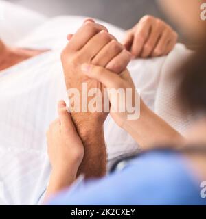 Con te in ogni fase del percorso. Primo piano di una mano di persone irriconoscibili che è tenuto da un medico all'interno di una clinica medica. Foto Stock