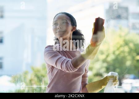 Li voglio così chiaro theyre invisibile. Scatto di una giovane donna che pulisce la sua finestra a casa. Foto Stock