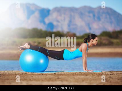 Inizia a vivere la tua vita migliore. Shot di una giovane donna che si sta allenando con una palla da ginnastica. Foto Stock