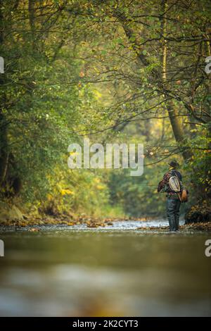 Pescatore a mosca la pesca con la mosca su di uno splendido fiume di montagna Foto Stock