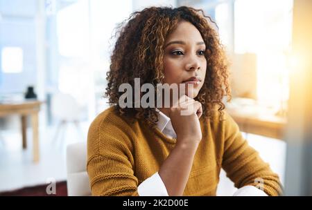 Vita in ufficio. Shot di una giovane donna d'affari focalizzata che si trova e lavora in ufficio sul posto di lavoro. Foto Stock