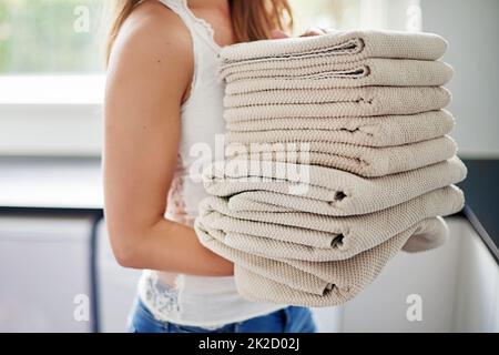 Il suo giorno di lavanderia. Scatto corto della giovane donna che fa il bucato a casa. Foto Stock