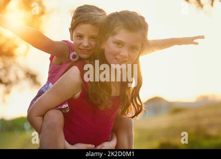 Tempo di gioco nel parco. Ritratto di due simpatiche sorelle che giocano insieme nel parco. Foto Stock