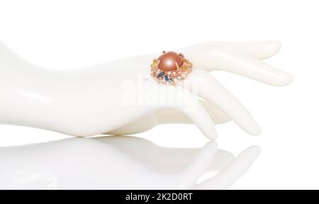 Anello giallo zaffiro con gemma di colore diverso su mano femminile manichino di plastica. Collezione di accessori per gemme naturali. Foto studio Foto Stock