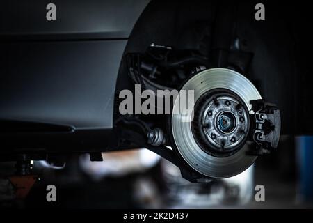 La sostituzione dei pneumatici - equilibratura delle ruote o la riparazione e la modifica dei pneumatici per auto al servizio di auto in garage o in officina dal meccanico Foto Stock