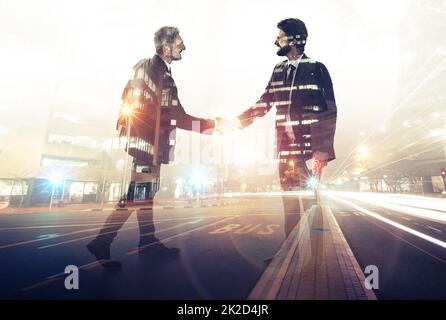 Il successo di affari è interamente circa i rapporti di costruzione. Esposizione multipla di due uomini d'affari che scuotono le mani sovrapposte su un'autostrada urbana. Foto Stock