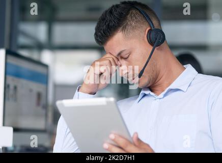 Non riesco a risolvere questo problema. Scatto di un giovane agente del call center che osserva stressato mentre lavora in ufficio. Foto Stock