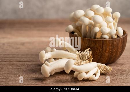 Shimeji, funghi bunapi freschi bianchi dell'Asia in ciotola di legno. Foto Stock