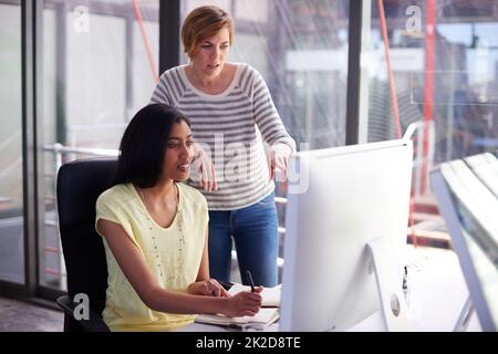 Che cosa se lo mettiamo là.... Ritratto di due colleghi che lavorano insieme su un computer. Foto Stock