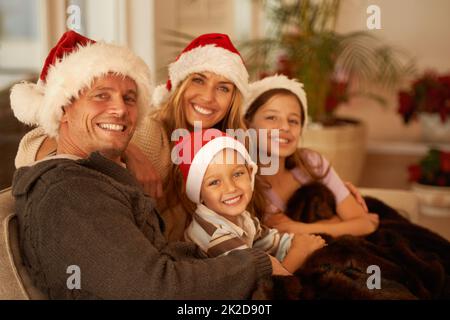 Momenti in famiglia a Natale. Ritratto di una giovane famiglia felice il giorno di Natale. Foto Stock