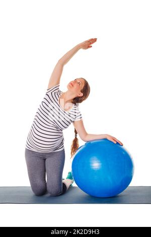 Donna incinta che fa le esercitazioni con la sfera di esercitazione Foto Stock