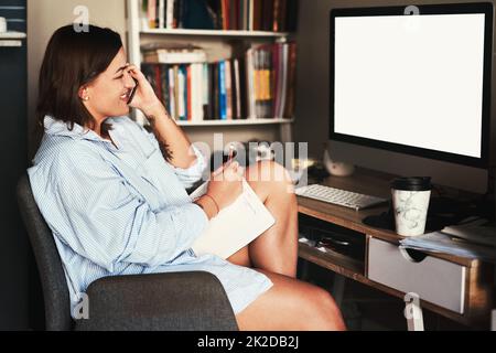 Le gioie di essere un freelance. Scatto corto di una giovane donna d'affari attraente seduta da sola nel suo ufficio domestico e usando il suo cellulare. Foto Stock