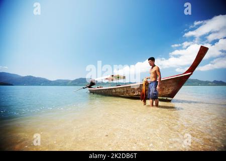 Pronto a lavorare. Tradizionale barca tailandese a coda lunga sulla spiaggia - Thailandia. Foto Stock