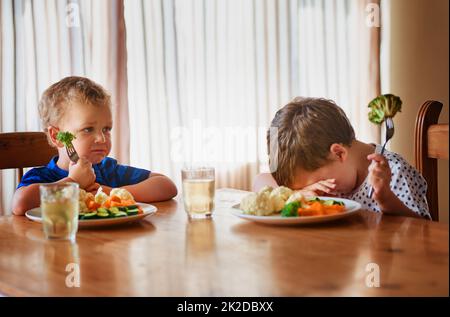 Thats esso, stavano andando su uno sciopero della fame. Shot di due ragazzi infelici che rifiutano di mangiare le loro verdure al tavolo della cena. Foto Stock