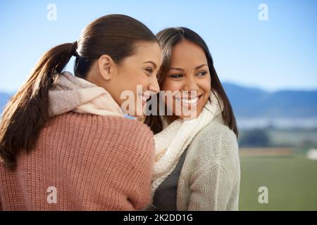 Amici - attraverso i bei tempi e cattivi. Due giovani donne in piedi fuori sorridendo felicemente. Foto Stock