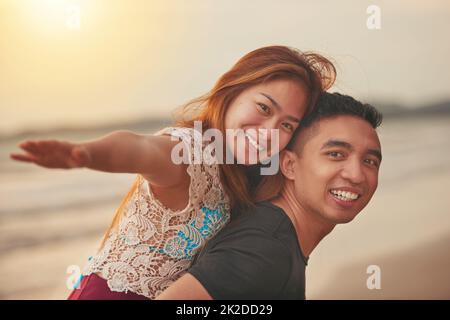 La spiaggia è il nostro posto preferito. Scatto corto di una coppia affettuosa che trascorre la giornata in spiaggia. Foto Stock