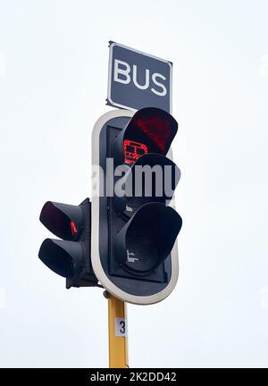 Solo autobus. Colpo di semafori contro un cielo grigio. Foto Stock