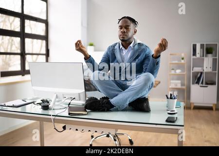 Dipendente africano che fa la salute mentale meditazione Yoga Foto Stock