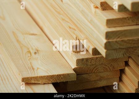 Pila di nuovi assi di legno su uno storage. Lato texture di sfondo Foto Stock