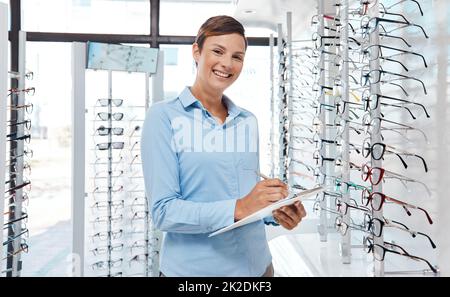 Donna d'affari, manager retail o dipendente optometristo scrivere, pianificare e prepararsi per l'assistenza, il lavoro o il punto vendita aperto. Sorridere ritratto Foto Stock