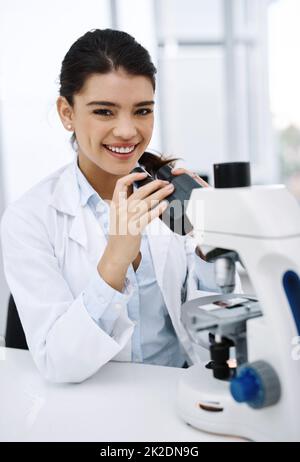 Ive è sempre stato curioso circa il mondo. Scatto di un giovane scienziato utilizzando un microscopio in un laboratorio. Foto Stock