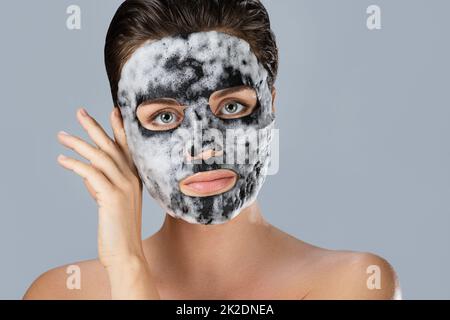 Donna con maschera bolla foglio sul suo viso Foto Stock