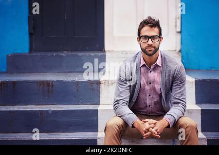 Fai un'affermazione con la tua moda. Scatto di un bel giovane uomo seduto su gradini. Foto Stock