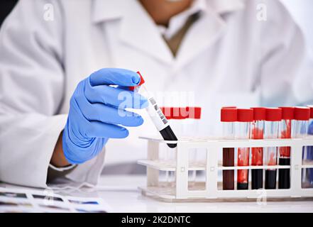 Pronto per analizzare del sangue. Scatto corto di uno scienziato maschile che conduce esami del sangue in un laboratorio medico. Foto Stock