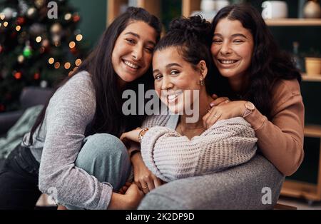 Che cosa è Natale senza le vostre ragazze. Scatto di giovani sorelle che si rilassano sul divano insieme durante il Natale a casa. Foto Stock
